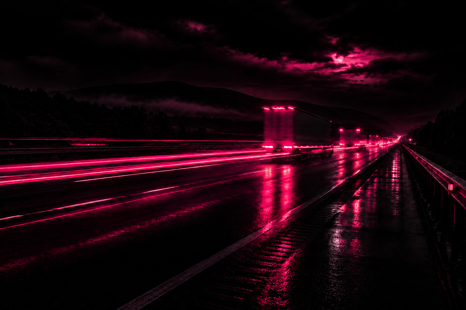 Truck taillights streaking down a wet interstate at night